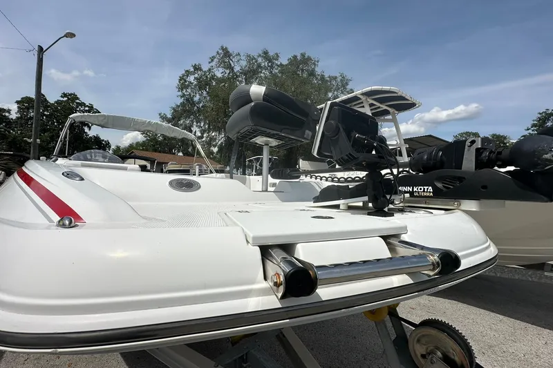 Slide: The Image of 2021 Tahoe 2150 boat with Minn Kota trolling motor, parked outdoors on a sunny day. - 3