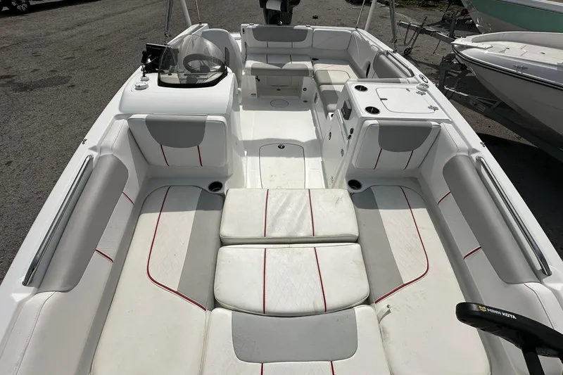 Slide: The Image of 2021 Tahoe 2150 boat interior with white and gray seating, red accents, and steering console. - 8