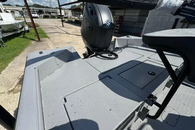 Slide: The Image of 2026 SeaArk Bay Runner 210 boat deck with motor, showcasing spacious layout and storage compartments. - 14