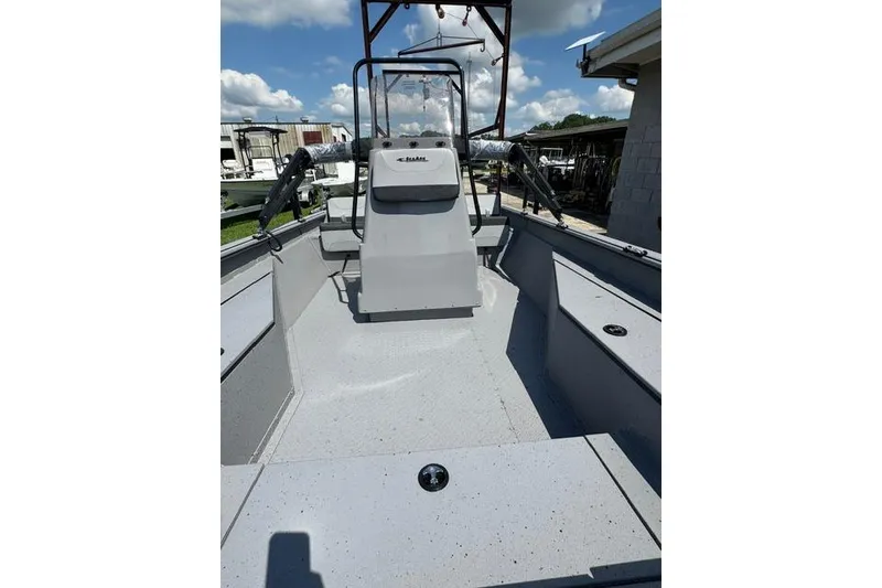 Slide: The Image of 2026 SeaArk Bay Runner 210 boat interior with console, under a clear blue sky. - 7