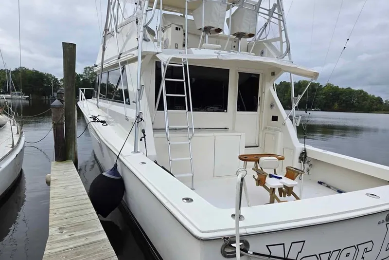 Slide: The Image of 1990 Viking 53 Convertible yacht docked, featuring spacious deck and fishing chair. - 12