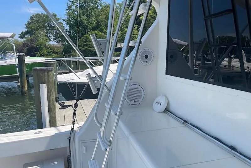 Slide: The Image of 1990 Viking 53 Convertible yacht docked, featuring sleek design and outdoor speakers. - 13