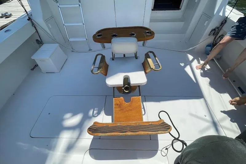 Slide: The Image of 1990 Viking 53 Convertible fishing chair on deck, featuring wooden armrests and rod holders. - 15