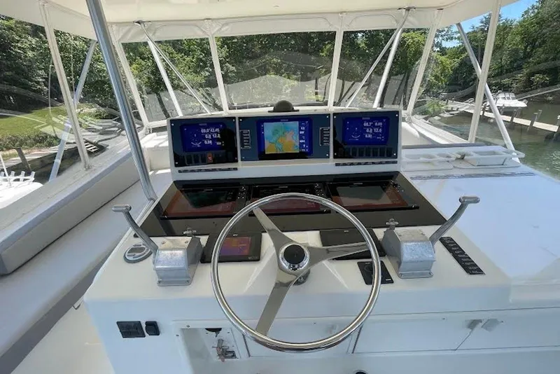Slide: The Image of Helm of 1990 Viking 53 Convertible yacht with modern navigation displays and controls. - 19