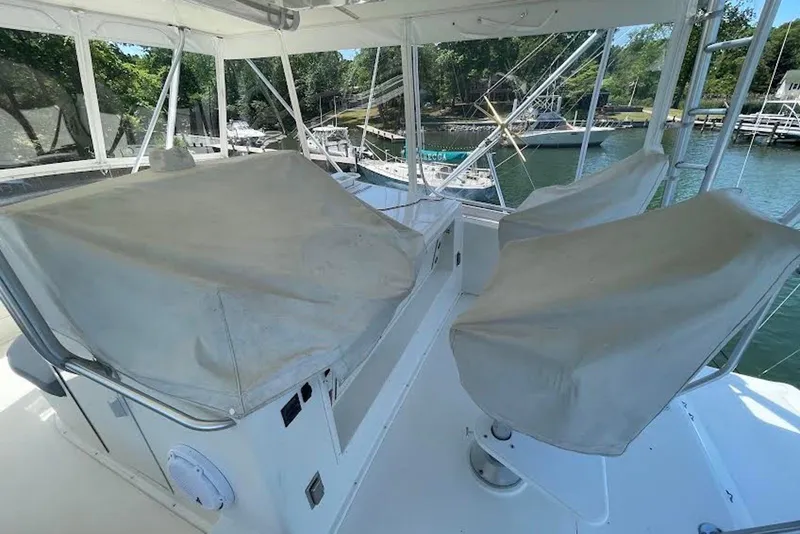 Slide: The Image of Covered seating area on a 1990 Viking 53 Convertible yacht, docked by the water. - 22