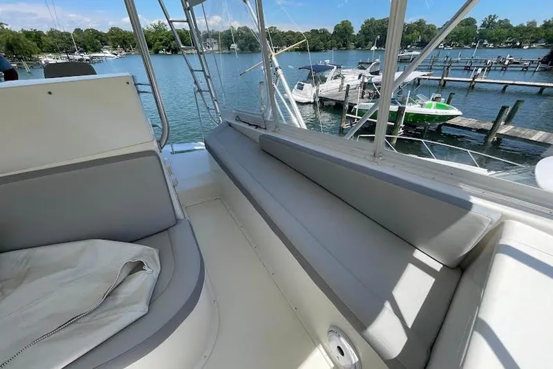 Slide: The Image of 1990 Viking 53 Convertible yacht interior with seating, overlooking marina and docked boats. - 25