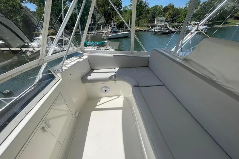 Slide: The Image of Interior view of a 1990 Viking 53 Convertible yacht with spacious seating and scenic marina backdrop. - 26
