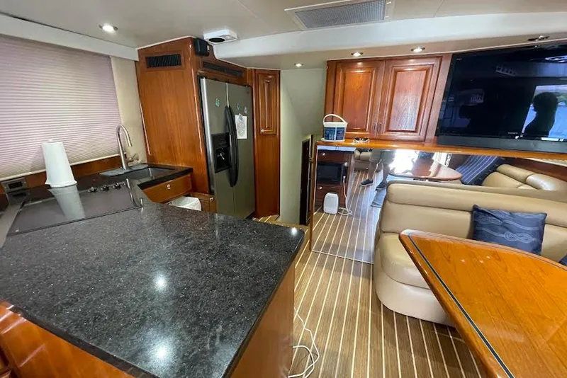 Slide: The Image of Luxurious interior of a 1990 Viking 53 Convertible yacht with modern kitchen and seating area. - 34