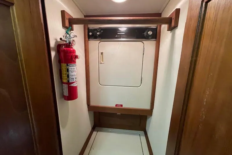 Slide: The Image of Laundry area with dryer and fire extinguisher on a 1990 Viking 53 Convertible yacht. - 41