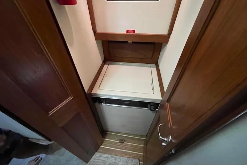 Slide: The Image of Laundry area inside a 1990 Viking 53 Convertible yacht, featuring a compact washer. - 42