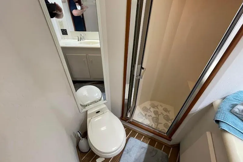 Slide: The Image of Bathroom interior of a 1990 Viking 53 Convertible yacht, featuring a toilet and shower. - 47
