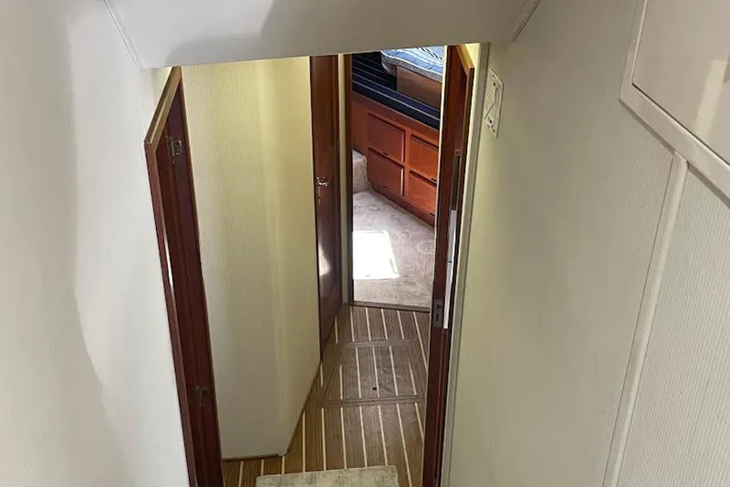 Slide: The Image of Interior hallway of a 1990 Viking 53 Convertible yacht, featuring wooden flooring and cabin access. - 48