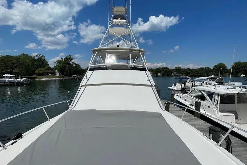Slide: The Image of 1990 Viking 53 Convertible yacht docked at marina under clear blue sky. - 5