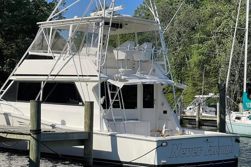 Slide: The Image of 1990 Viking 53 Convertible yacht docked, featuring a spacious flybridge and sleek design. - 7