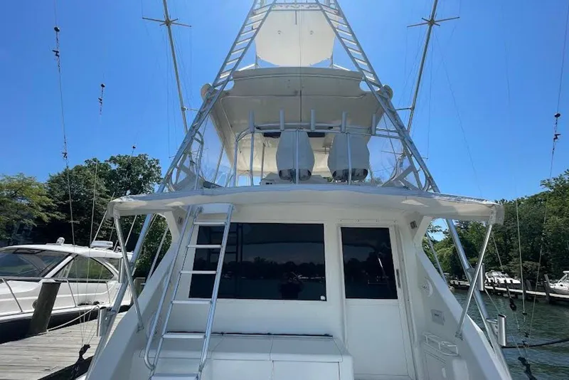 Slide: The Image of 1990 Viking 53 Convertible yacht with tower, docked under clear blue sky. - 8