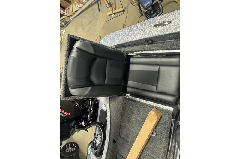 Slide: The Image of 2026 Nitro ZV19 Sport Pro boat interior with black cushioned seating and storage compartment. - 23