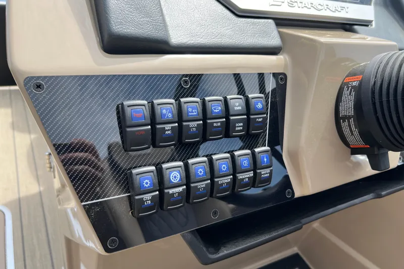 Slide: The Image of Control panel of 2026 Starcraft SLS 3 R boat with labeled switches and carbon fiber finish. - 12