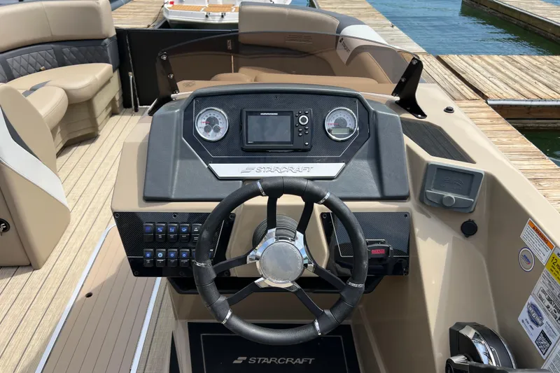Slide: The Image of 2026 Starcraft SLS 3 R boat dashboard with steering wheel and control panel at dock. - 9