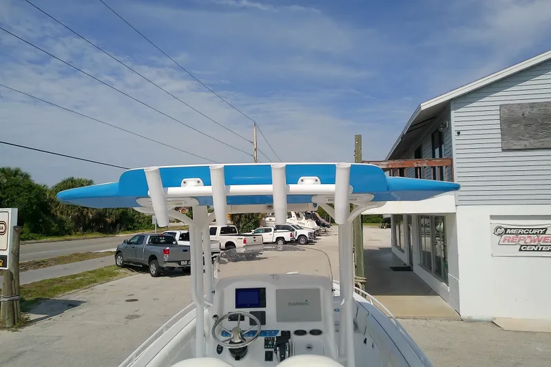 Slide: The Image of 2022 Glasstream 280 Pro-XS boat with blue canopy, parked near a marine center. - 15