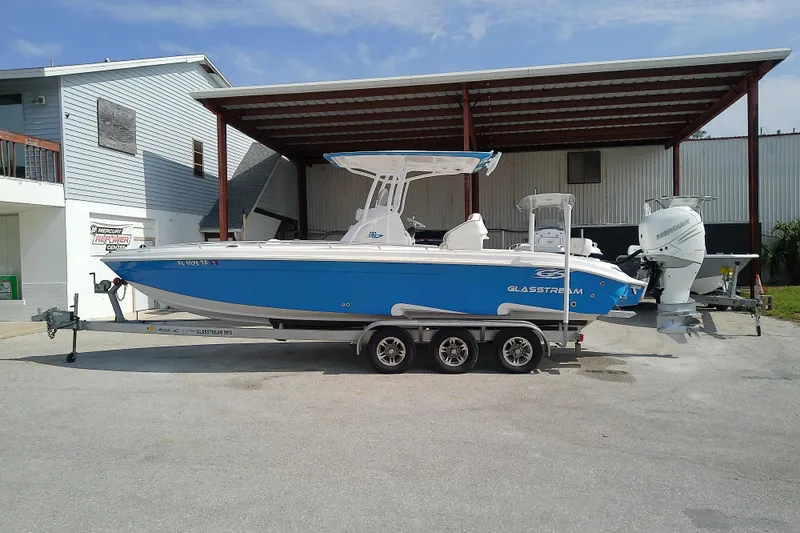 Slide: The Image of 2022 Glasstream 280 Pro-XS boat on trailer, parked near a building. - 2