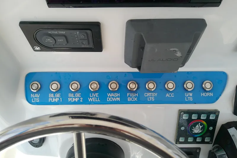 Slide: The Image of Control panel of a 2022 Glasstream 280 Pro-XS boat with various switches and audio system. - 33