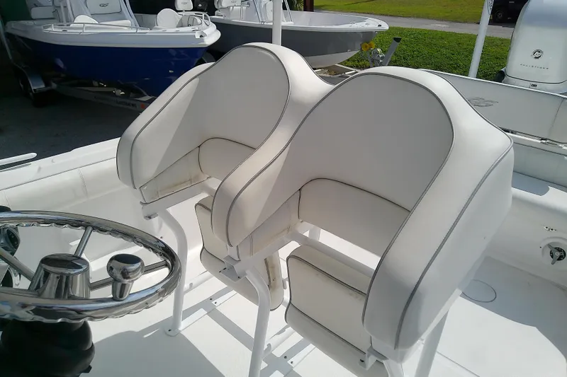 Slide: The Image of 2022 Glasstream 280 Pro-XS boat interior with white cushioned seats and steering wheel. - 40