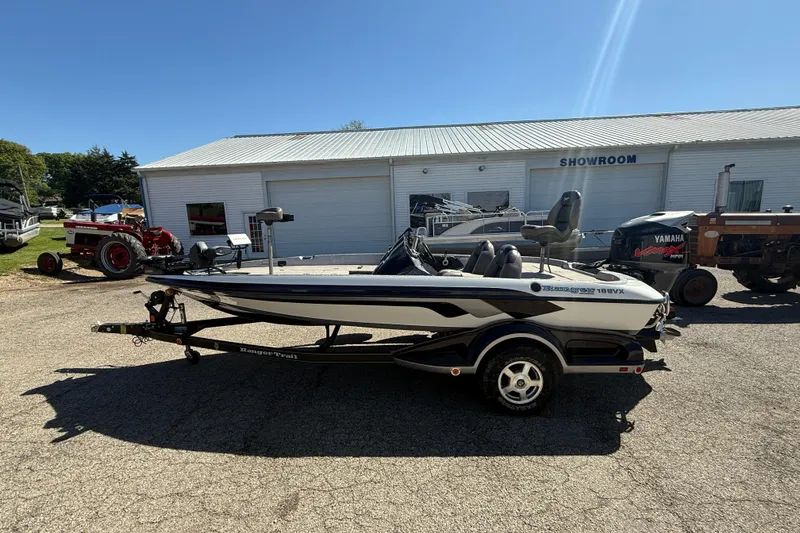 The Image of 2009 Ranger 188 VX boat parked outside a showroom on a sunny day. - 1