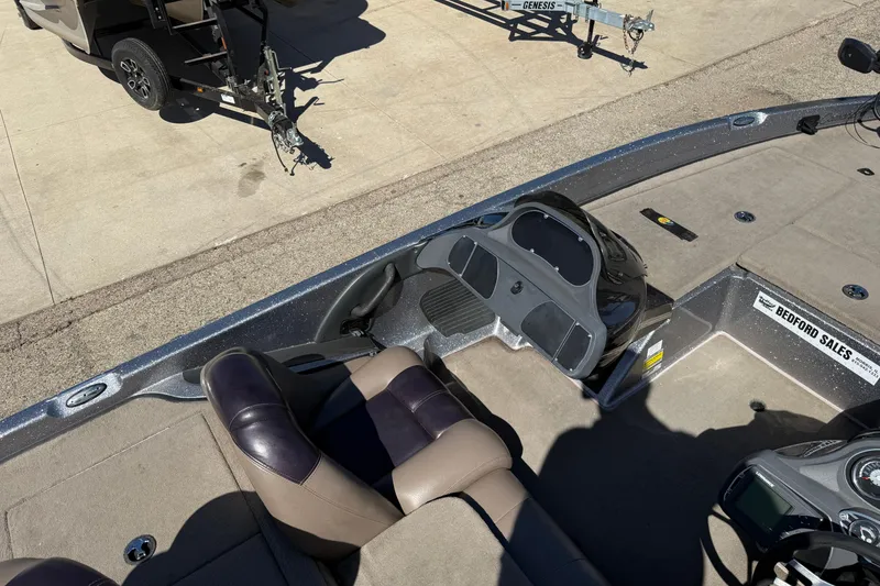 Slide: The Image of 2009 Ranger 188 VX boat interior with seating and dashboard, parked on concrete. - 21