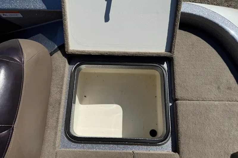 Slide: The Image of Open storage compartment in 2009 Ranger 188 VX boat, featuring beige upholstery. - 26