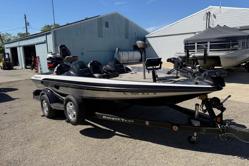 Slide: The Image of 2009 Ranger 188 VX boat on trailer, parked near industrial buildings. - 4