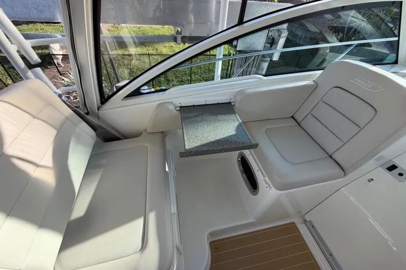 Slide: The Image of 2018 Boston Whaler 315 Conquest interior seating with table, showcasing luxury and comfort. - 13