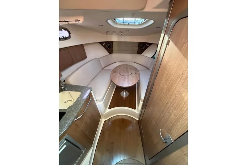 Slide: The Image of 2018 Boston Whaler 315 Conquest cabin interior with seating and table. - 16