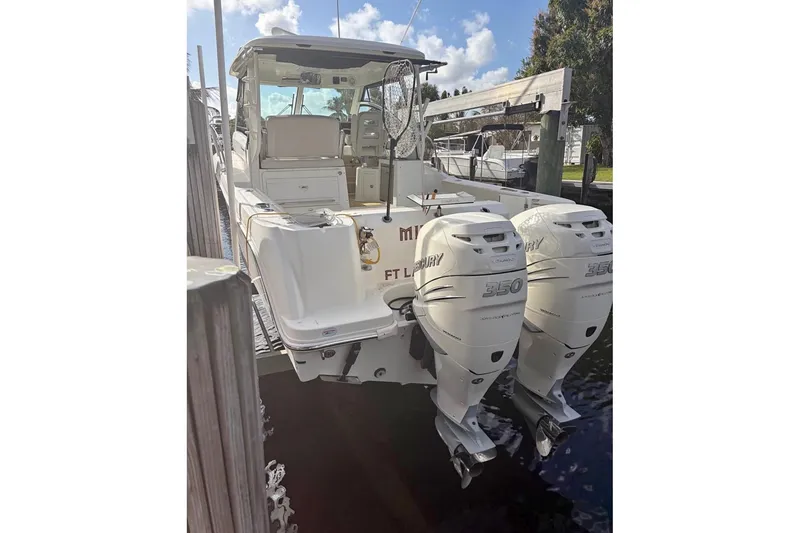 Slide: The Image of 2018 Boston Whaler 315 Conquest with twin Mercury 350 engines docked. - 2