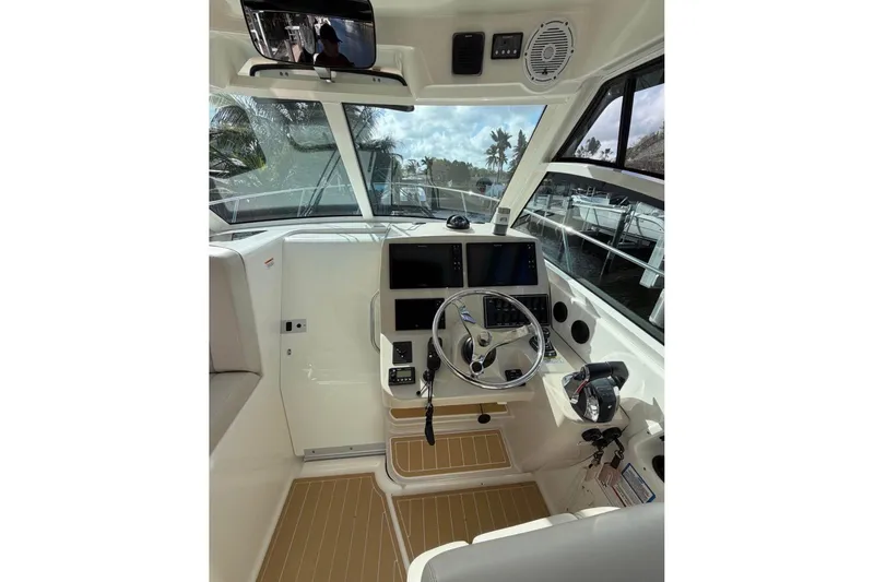 Slide: The Image of 2018 Boston Whaler 315 Conquest helm with modern controls and navigation equipment. - 8