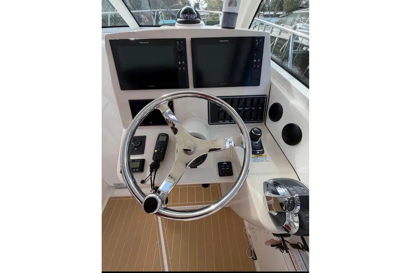 Slide: The Image of Cockpit of 2018 Boston Whaler 315 Conquest with dual screens and modern controls. - 9