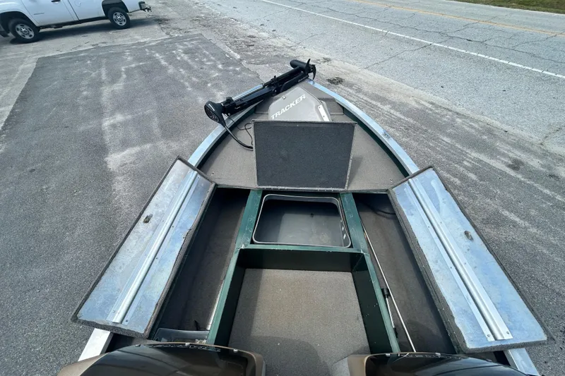 Slide: The Image of 1996 Tracker Tournament V-17 boat with open storage compartments on a paved surface. - 13