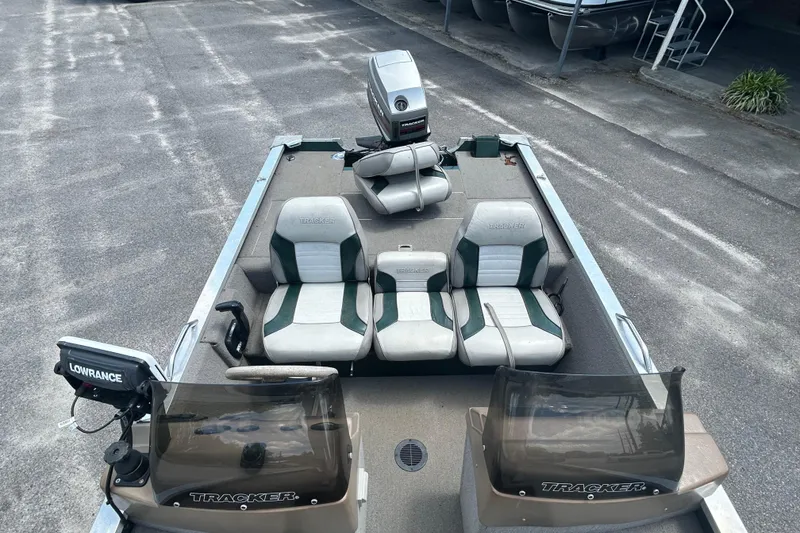 Slide: The Image of 1996 Tracker Tournament V-17 boat with seating and Lowrance equipment, parked on pavement. - 14