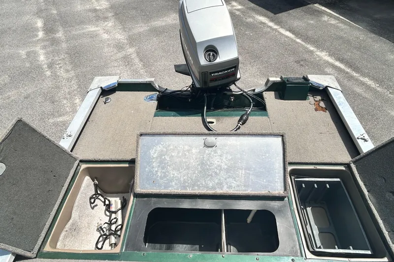 Slide: The Image of 1996 Tracker Tournament V-17 boat interior with open storage compartments and motor. - 15