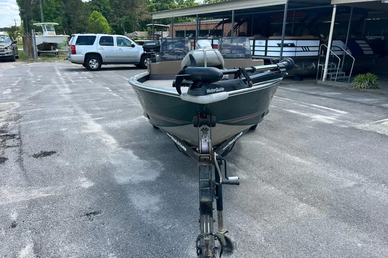 Slide: The Image of 1996 Tracker Tournament V-17 boat on trailer in parking lot, surrounded by vehicles. - 6