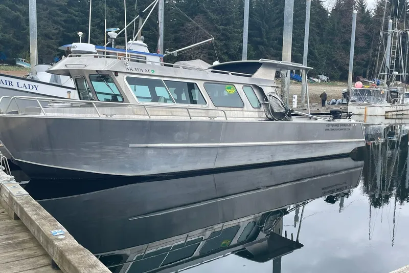 Slide: The Image of A 2005 Lifetimer 3540 boat docked in a marina, reflecting on calm water. - 29
