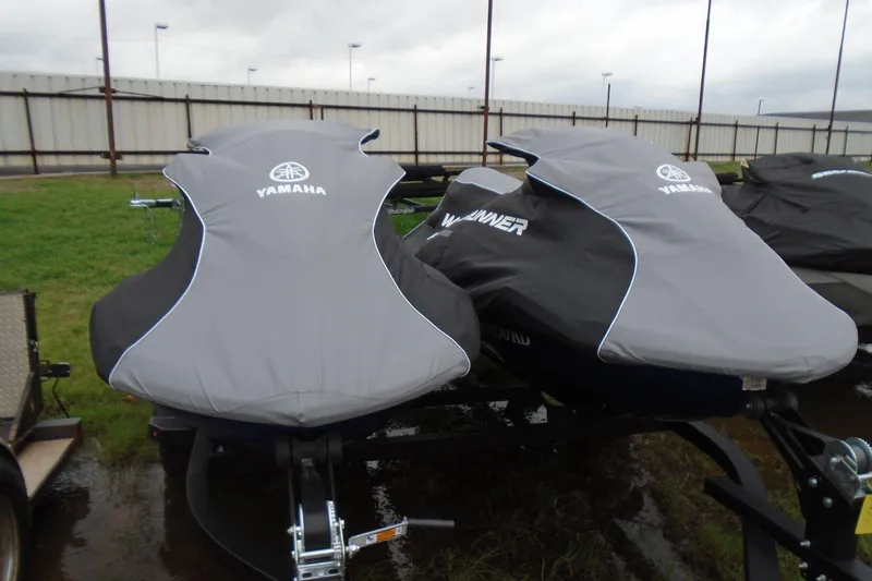 Slide: The Image of 2021 Yamaha WaveRunner FX Cruiser HO jet skis covered, parked on a trailer. - 2