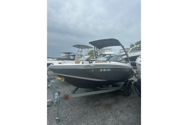 The Image of 2021 Yamaha Boats 195S on trailer, parked outdoors under cloudy sky. - 1