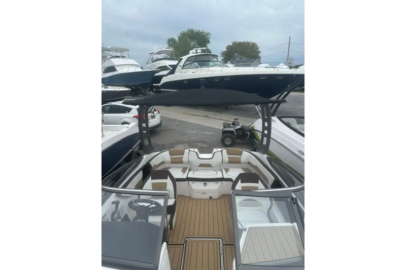 Slide: The Image of 2021 Yamaha Boats 195S with spacious seating and sleek design in a marina setting. - 12