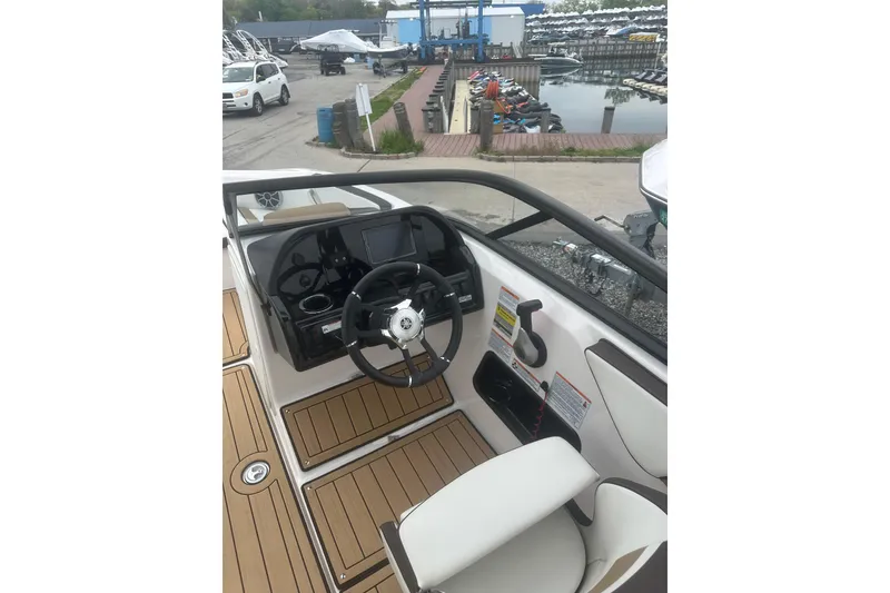 Slide: The Image of 2021 Yamaha Boats 195S cockpit with steering wheel and dashboard, dockside view. - 20