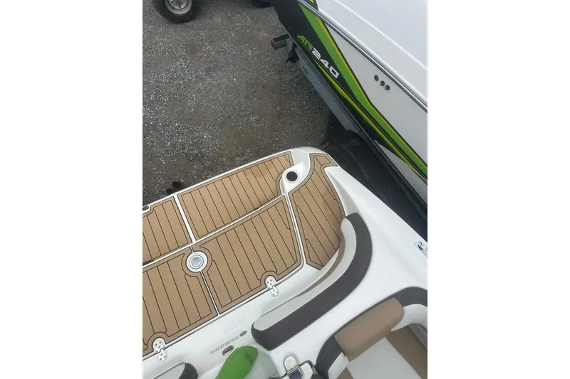 Slide: The Image of 2021 Yamaha Boats 195S deck with brown and white seating, adjacent to a trailer. - 26