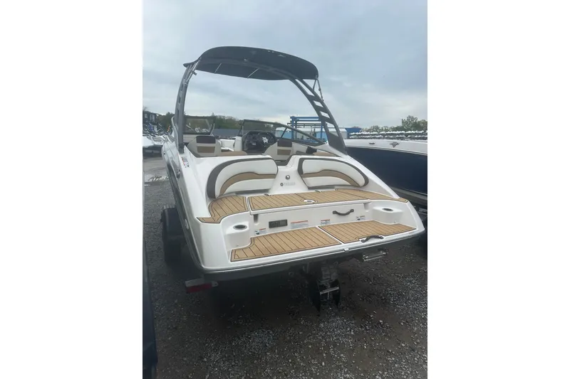 Slide: The Image of 2021 Yamaha Boats 195S with sleek design and spacious seating, parked outdoors. - 4