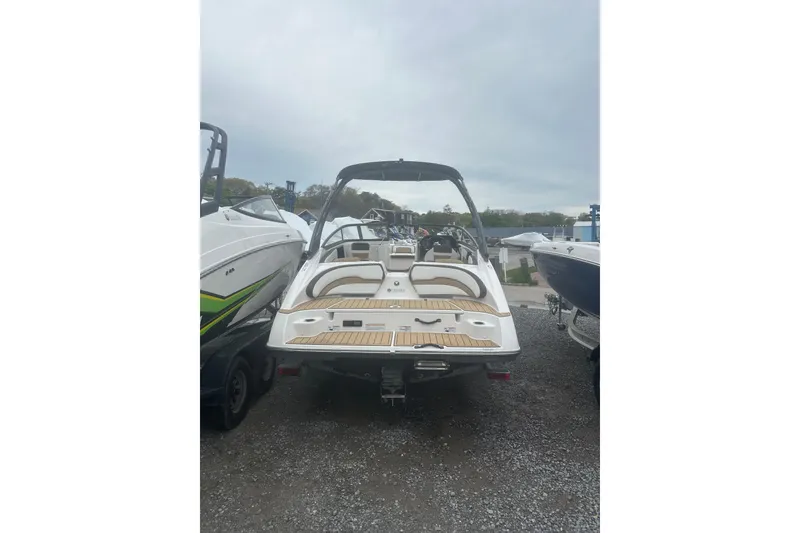 Slide: The Image of 2021 Yamaha Boats 195S, rear view, parked on gravel, showcasing sleek design and spacious seating. - 6