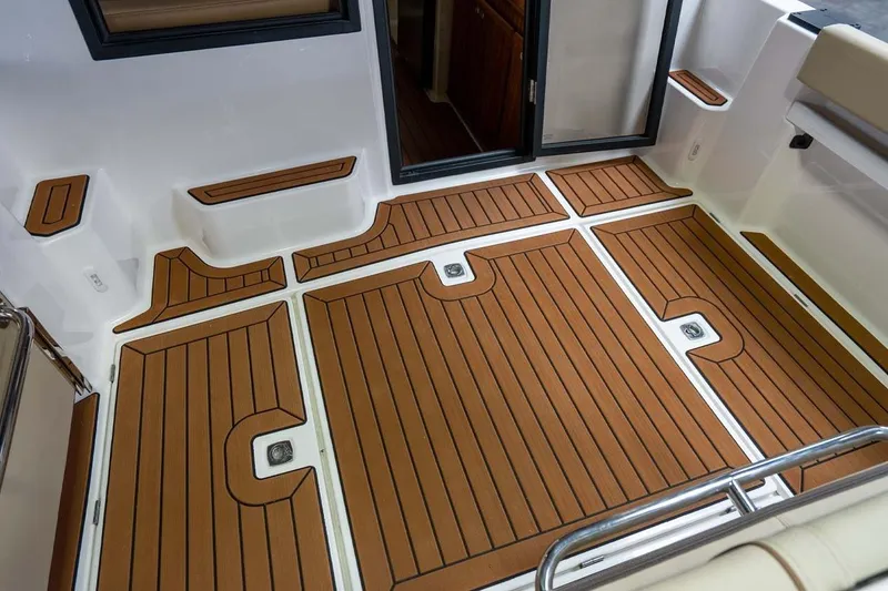 Slide: The Image of 2025 Ranger Tugs R-25 boat deck with teak-style flooring and sleek design. - 10