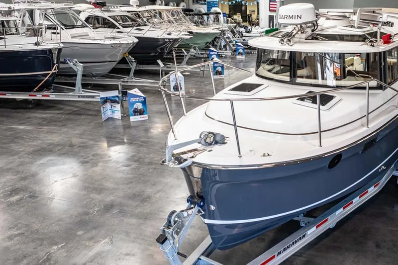 Slide: The Image of 2025 Ranger Tugs R-25 boat displayed in a showroom on a trailer. - 2