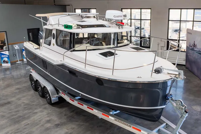 Slide: The Image of 2025 Ranger Tugs R-25 boat on trailer in showroom, featuring sleek design and modern equipment. - 3